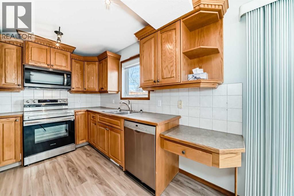Stainless steel fridge and stove replaced in 2023 and brand new microwave hood fan - 21 Hillview Road, Strathmore, AB - Indoor Photo Showing Kitchen With Double Sink