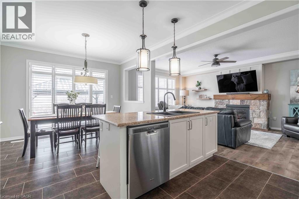 Overall view of primary living space. Note the large patio door to exterior and the custom wood Califormia shutters. - 115 Larry Crescent, Caledonia, ON - Indoor Photo Showing Kitchen With Fireplace With Double Sink With Upgraded Kitchen