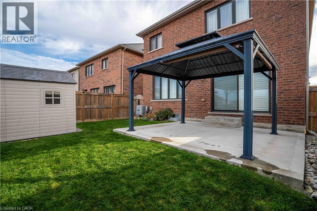 Back of property with a gazebo, a fenced backyard, a patio, and brick siding - 115 Larry Crescent, Caledonia, ON - Outdoor With Exterior