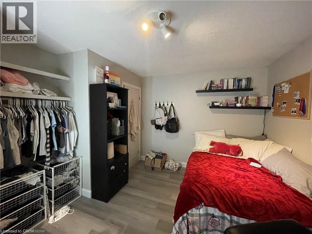 Bedroom featuring wood finished floors, a textured ceiling, and a closet - 18 Rosewell Street, Hamilton, ON - Indoor Photo Showing Bedroom