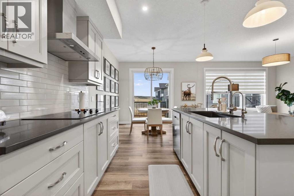 Warm cabinetry and quartz countertops - 307 Precedence Hill, Cochrane, AB - Indoor Photo Showing Kitchen With Upgraded Kitchen