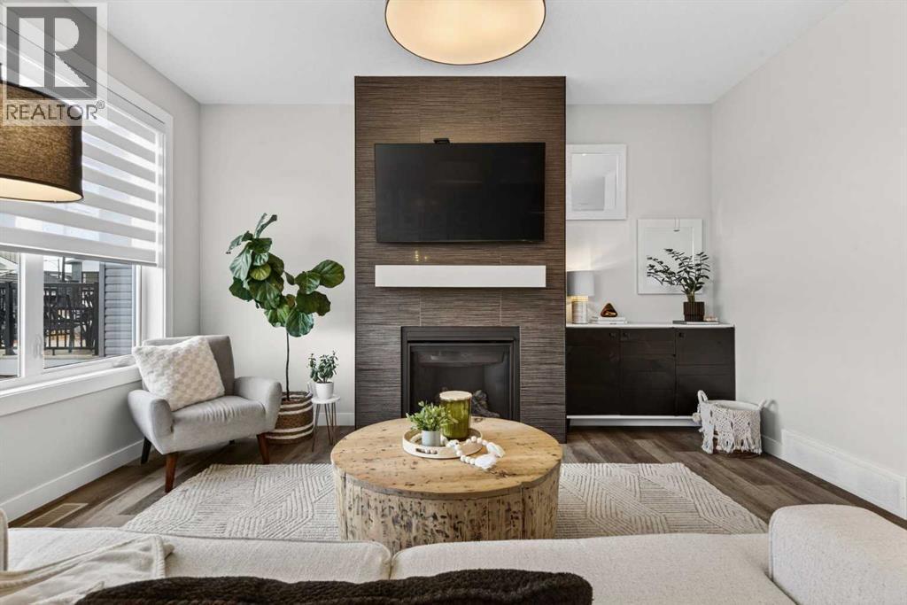 Bright and large living room with gas fireplace, automatic blinds and warm touoches - 307 Precedence Hill, Cochrane, AB - Indoor Photo Showing Living Room With Fireplace