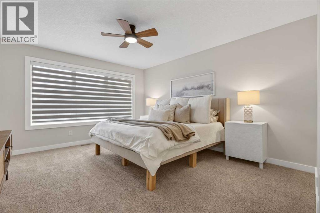 Spacious primary bedroom with large east facing window with custom blinds - 307 Precedence Hill, Cochrane, AB - Indoor Photo Showing Bedroom