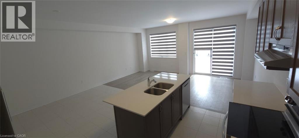 Kitchen featuring open floor plan, range hood, an island with sink, range with electric stovetop, and stainless steel dishwasher - 925 Douro Street, Stratford, ON - Indoor Photo Showing Kitchen With Double Sink