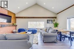 Living room featuring vaulted ceiling, light wood finished floors, and recessed lighting -