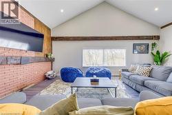 Living room with wood finished floors, lofted ceiling, baseboards, and recessed lighting -