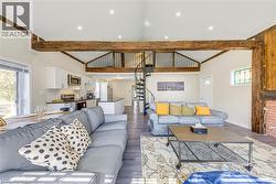 Living room featuring stairs, wood finished floors, and baseboards -