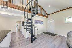 Foyer entrance with high vaulted ceiling, wood finished floors, baseboards, stairway, and recessed lighting -