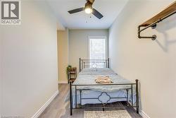 Bedroom with wood finished floors, baseboards, and a ceiling fan -