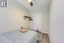 Bedroom with light wood-type flooring, baseboards, and a ceiling fan -