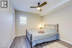 Bedroom featuring baseboards, wood finished floors, and ceiling fan -
