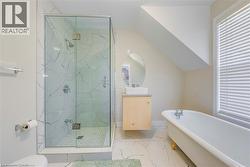 Bathroom with a freestanding bath, a marble finish shower, marble finish flooring, vanity, and vaulted ceiling -