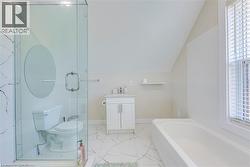 Full bathroom with toilet, vaulted ceiling, a garden tub, marble finish floors, and a stall shower -