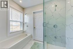 Full bath featuring marble look tile flooring -