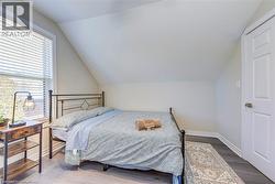 Bedroom featuring lofted ceiling, wood finished floors, and baseboards -
