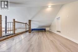 Bonus room with wood finished floors, lofted ceiling, and baseboards -