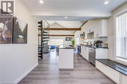 Kitchen with stainless steel appliances, dark countertops, lofted ceiling, recessed lighting, and white cabinetry -