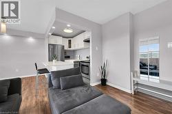 Kitchen featuring glass insert cabinets, light countertops, appliances with stainless steel finishes, dark wood-type flooring, and backsplash -