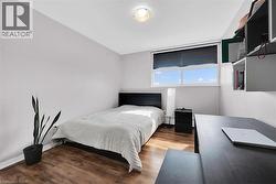 Bedroom featuring baseboards and wood finished floors -