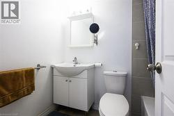 Bathroom with toilet, vanity, and a shower -