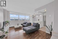 Living area with a baseboard radiator, wood-type flooring, baseboards, and recessed lighting -