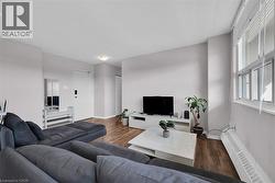 Living room featuring a baseboard radiator, wood finished floors, and baseboards -