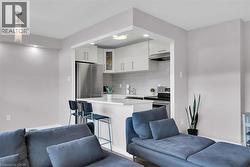 Kitchen with open floor plan, tasteful backsplash, under cabinet range hood, and appliances with stainless steel finishes -