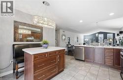 Kitchen featuring hanging light fixtures, vaulted ceiling, dishwasher, a center island, and open floor plan -