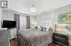 Bedroom featuring dark wood-type flooring and a chandelier -