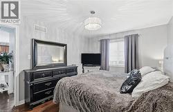 Bedroom featuring dark wood-style flooring and a chandelier -