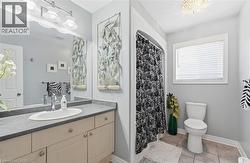 Full bathroom with vanity, a shower with shower curtain, and light tile patterned floors -
