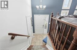 Entrance foyer featuring a chandelier, light tile patterned floors, and a high ceiling -