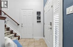 Entryway with light tile patterned floors and stairway -