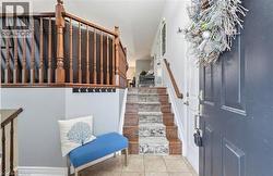 Entryway with stairs and light tile patterned floors -