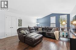 Living area featuring a chandelier, dark wood finished floors, and lofted ceiling -