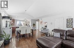 Living room featuring lofted ceiling, dark wood-style floors, and a chandelier -