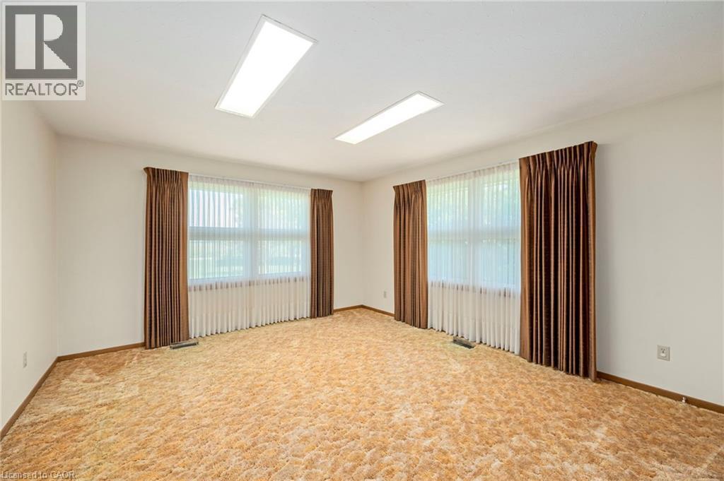 Carpeted empty room featuring plenty of natural light - 6828 Third Line, Chatham, ON