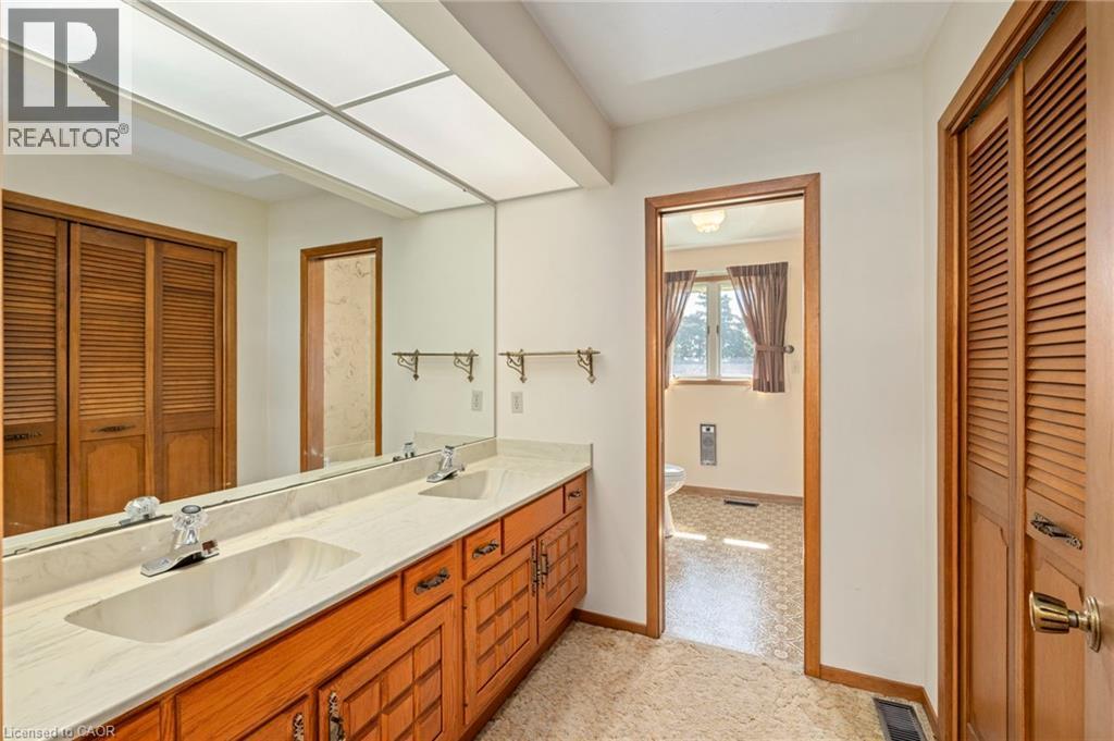 Full bath featuring a closet, double vanity, and heating unit - 6828 Third Line, Chatham, ON
