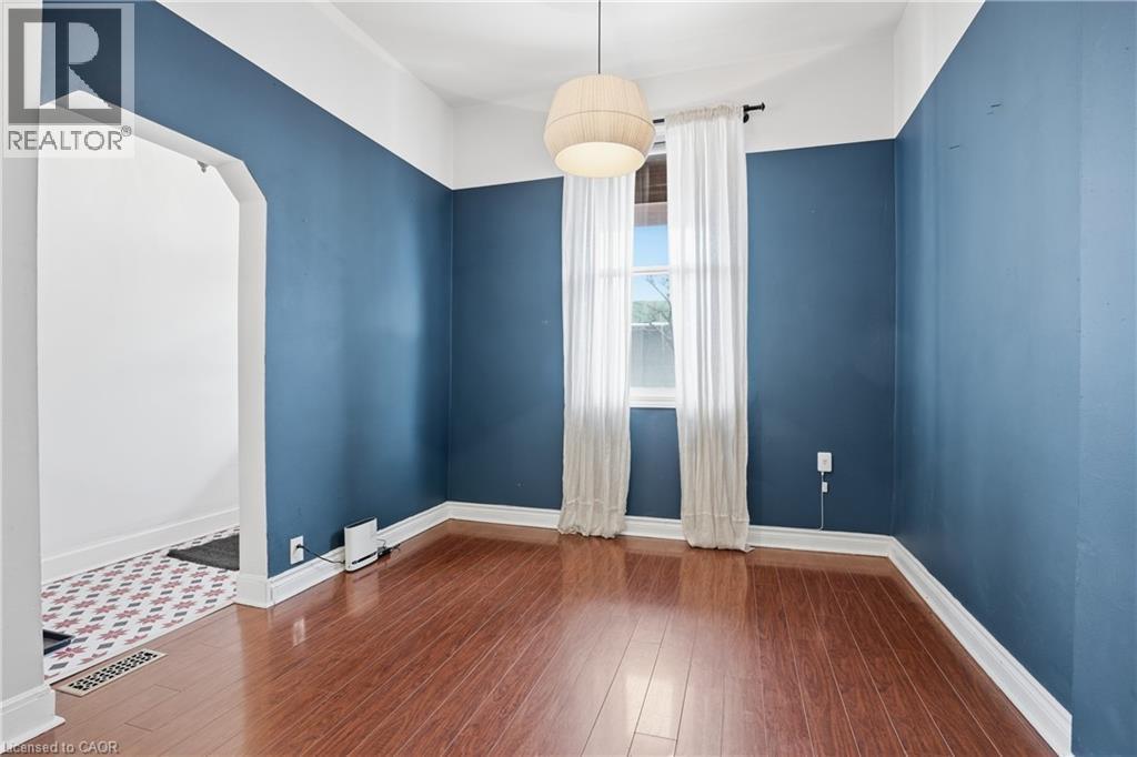 Unfurnished room featuring arched walkways and dark wood finished floors - 313 Mary Street, Hamilton, ON - Indoor Photo Showing Other Room