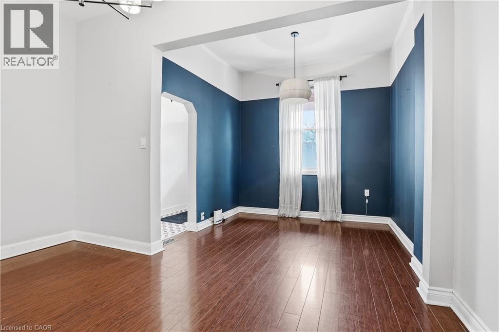 Unfurnished dining area featuring dark wood-style flooring and arched walkways - 313 Mary Street, Hamilton, ON - Indoor Photo Showing Other Room