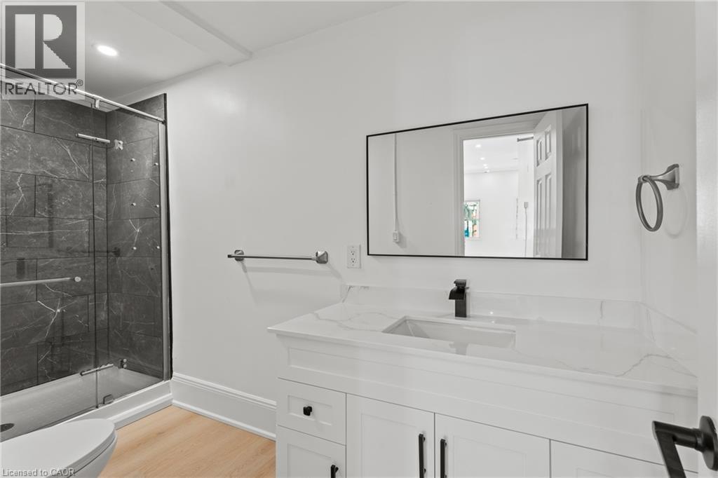 Full bathroom with vanity, a marble finish shower, light wood-type flooring, and recessed lighting - 93 John Street S, Hamilton, ON