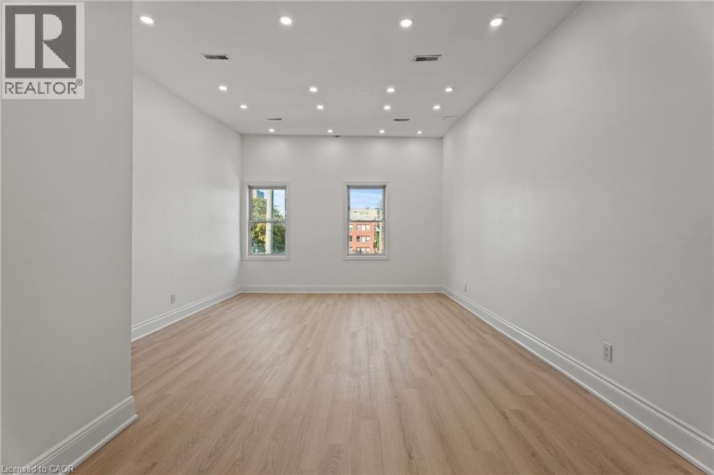 Unfurnished room featuring light wood-style flooring and recessed lighting - 93 John Street S, Hamilton, ON