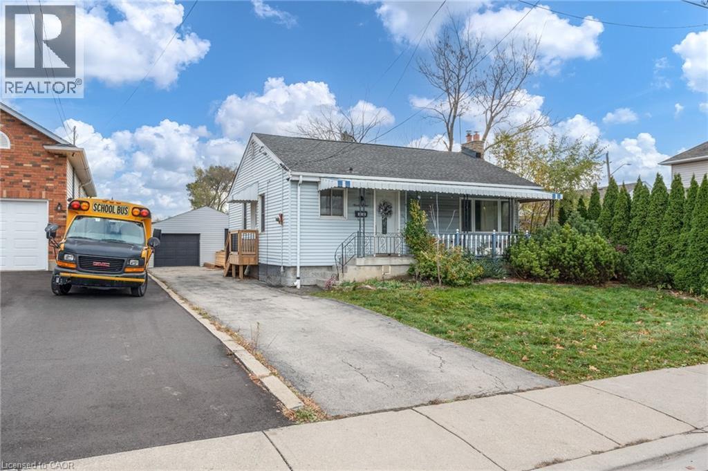 View of front of house featuring an outbuilding, a garage, and a front lawn - 99 East 36Th Street, Hamilton, ON - Outdoor With Deck Patio Veranda