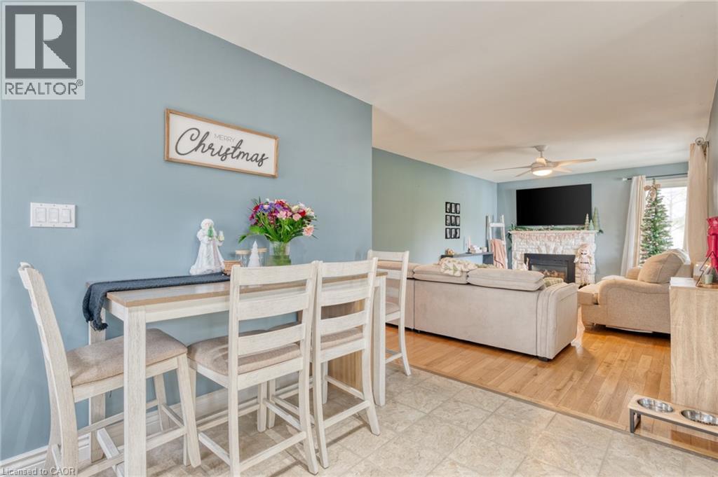 Dining room featuring a fireplace, wood-type flooring, and ceiling fan - 99 East 36Th Street, Hamilton, ON - Indoor With Fireplace