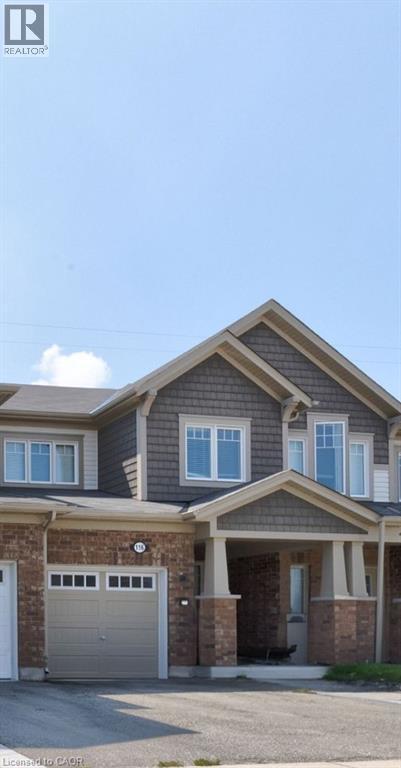 View of front of property featuring covered porch, brick siding, and asphalt driveway - 116 Watermill Street, Kitchener, ON - Outdoor With Facade