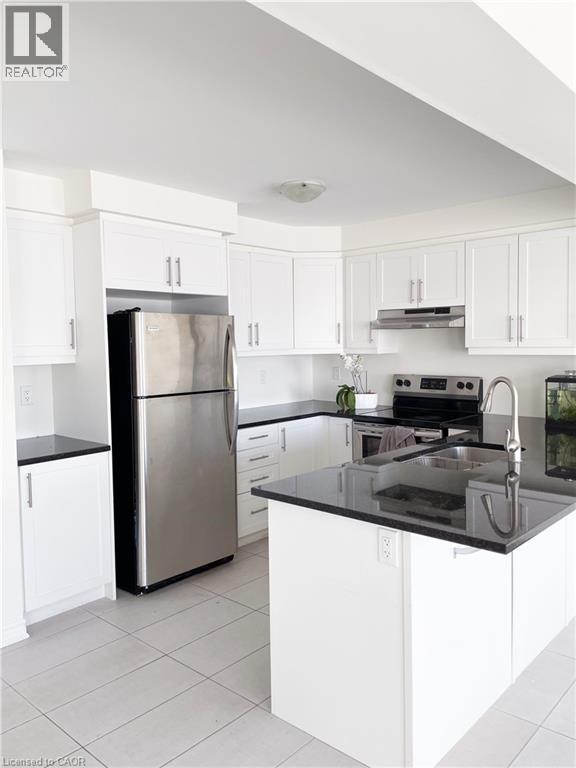 Kitchen with white cabinets, appliances with stainless steel finishes, and dark stone countertops - 116 Watermill Street, Kitchener, ON - Indoor Photo Showing Kitchen With Stainless Steel Kitchen With Double Sink