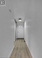 Doorway with wood finished floors and baseboards -