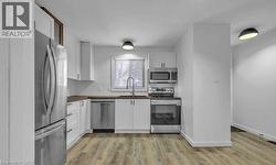 Kitchen featuring appliances with stainless steel finishes, white cabinets, butcher block counters, and light wood finished floors -
