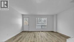 Foyer entrance with light wood-style flooring and baseboards -