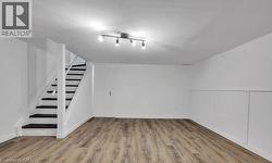 Basement featuring stairway and light wood-type flooring -